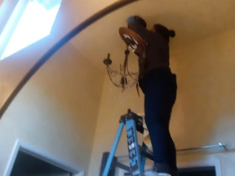 Electrician installing a chandelier in a Republic residence